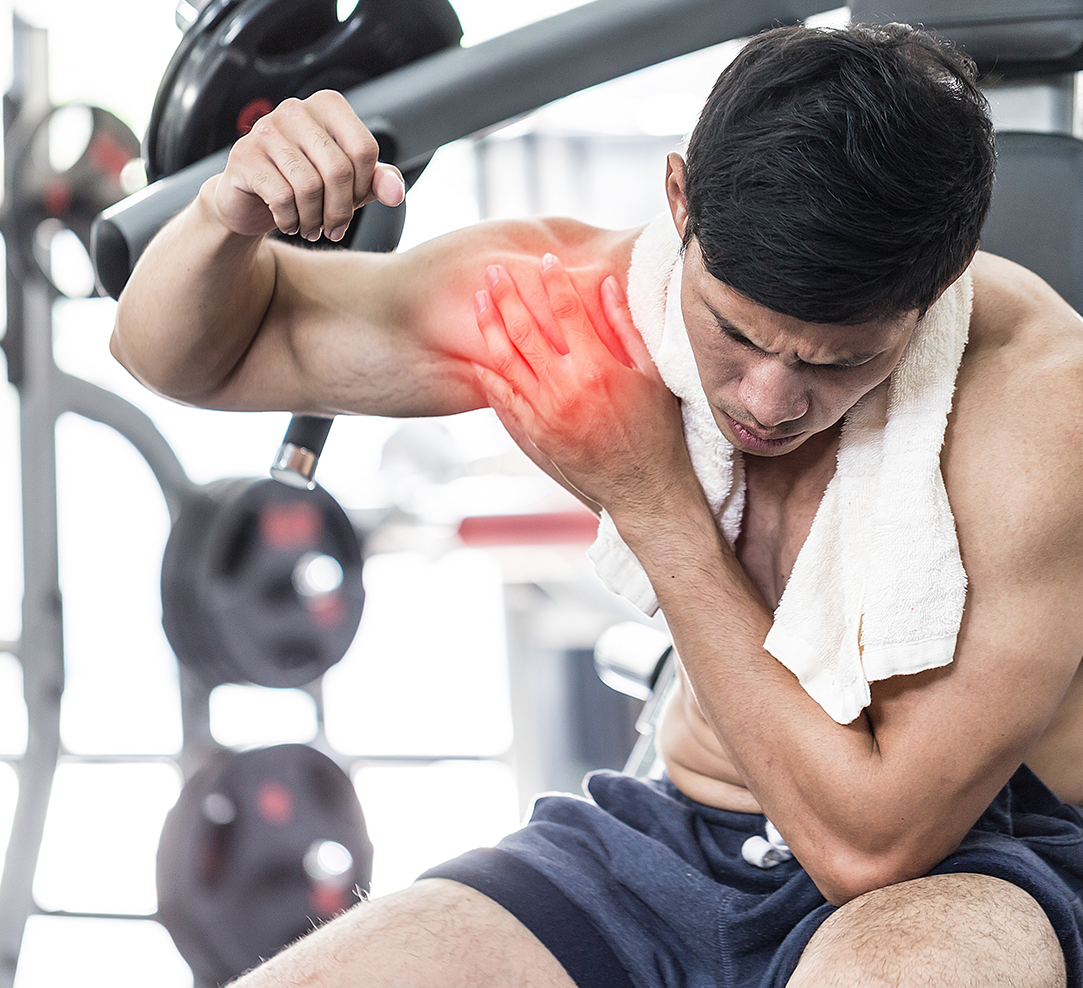 An athlete at the gym experiencing shoulder pain